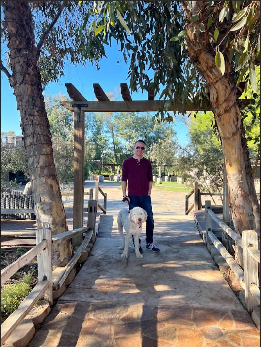 Handsome man and his sheepadoodle posing at Vigtaliano Winery.